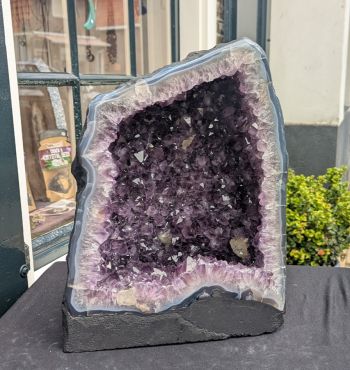 Extra ruwe Amethist Geode  middenmaat met donkerpaarse grotere en kleinere kristallen